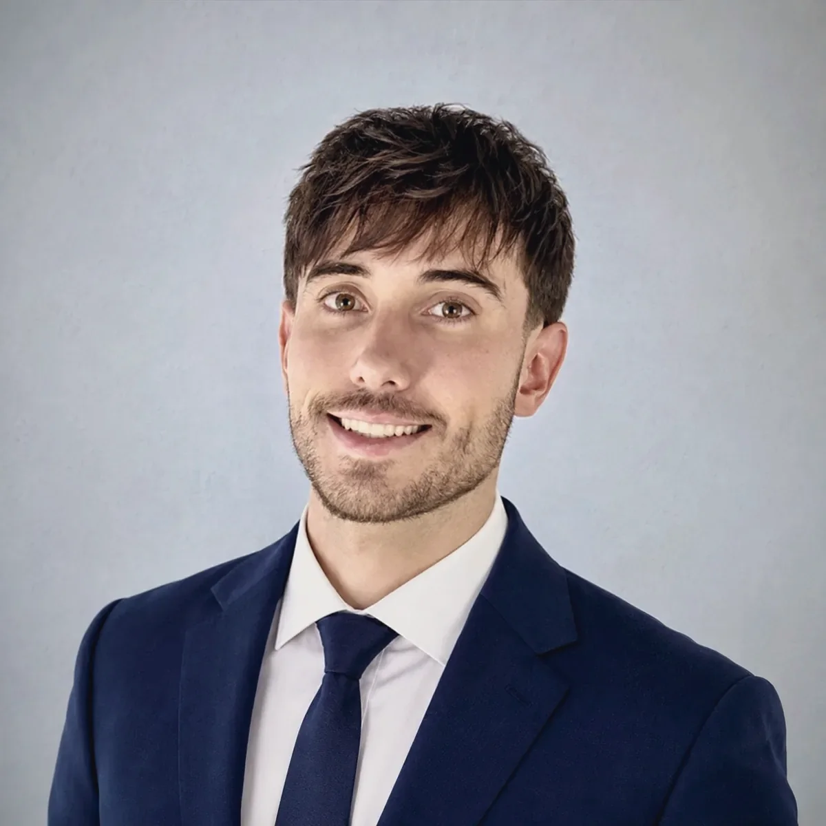 Alexander Weiskopf in a navy suit and tie against a blue-grey background