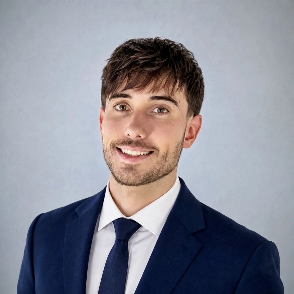 Alexander Weiskopf in a navy suit and tie against a blue-grey background